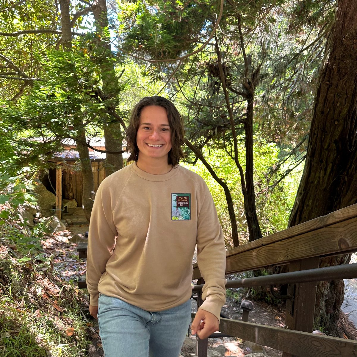Esalen Apparel & Accessories - Esalen Embroidered Reservations Only Sweatshirt in Tan on smiling staff member
